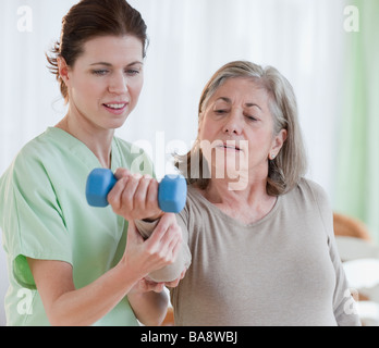 Physical therapist helping senior woman Stock Photo