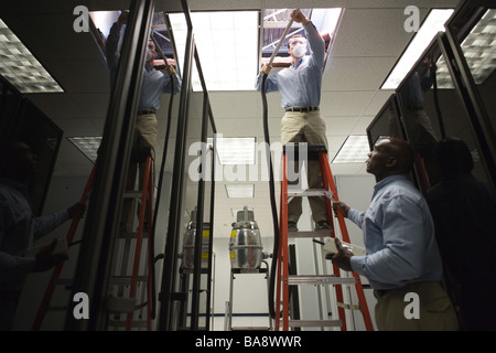 Computer technicians clean servers in high tech environment. Stock Photo
