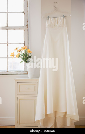 Wedding dress hanging in bed room Stock Photo