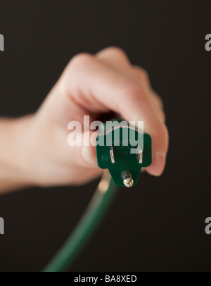 Close up of hand holding electric plug Stock Photo