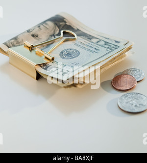 Coins and dollar bills in money clip Stock Photo