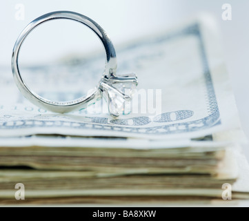 Wedding ring on stack of cash Stock Photo