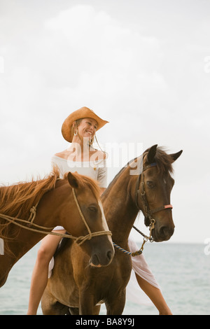 Woman riding horse on beach Stock Photo