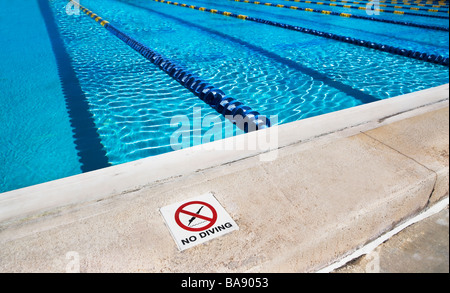 No diving sign on edge of swimming pool Stock Photo