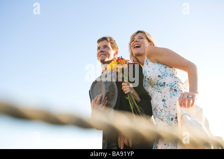 Low angle view of happy couple holding bouquet, smiling Stock Photo