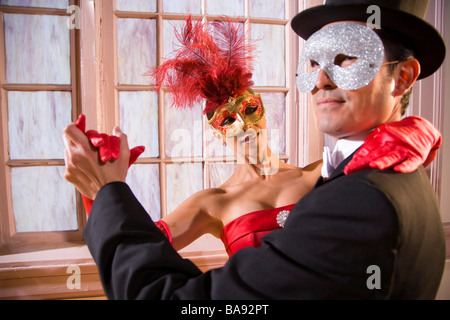 Couple in masquerade costumes dancing together Stock Photo