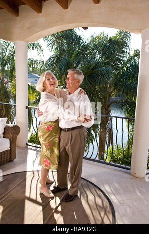 Portrait of senior couple dancing on veranda of house Stock Photo