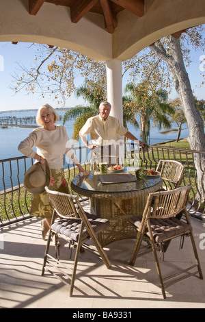 Portrait of senior couple relaxing on veranda of house Stock Photo