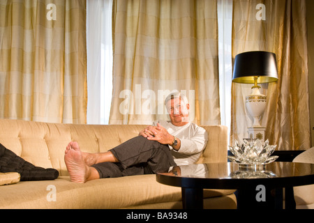 Portrait of senior man relaxing on couch at home Stock Photo