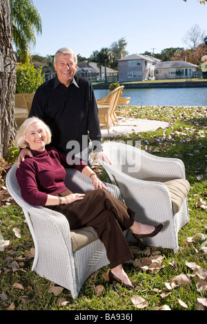 Portrait of senior couple in yard of luxurious home Stock Photo