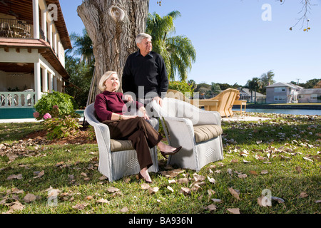 Portrait of senior couple in yard of luxurious home Stock Photo