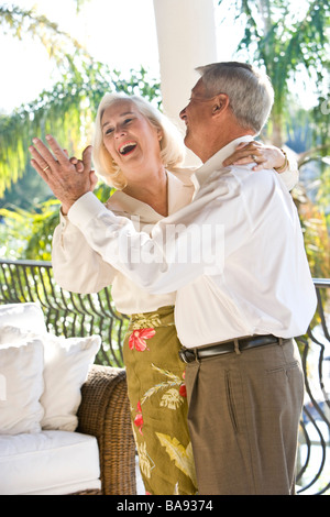 Portrait of senior couple dancing on veranda of house Stock Photo