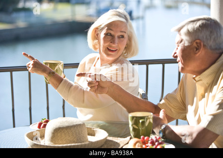 Portrait of senior couple relaxing on veranda of house Stock Photo