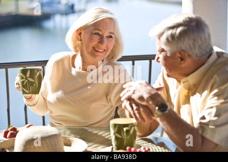 Portrait of senior couple relaxing on veranda of house Stock Photo