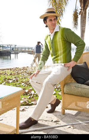 Portrait of 1920s socialite men relaxing at garden party on water's edge Stock Photo