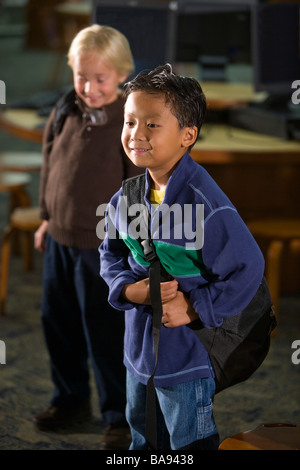 Asian and Caucasian elementary school boys in library Stock Photo