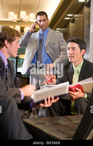 Portrait of multi-racial businessmen working in modern lobby Stock Photo