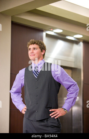 Businessman waiting for elevator in office lobby Stock Photo