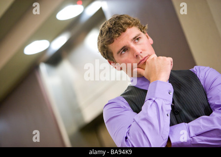 Serious businessman thinking and waiting for elevator in office lobby Stock Photo