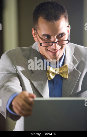 Businessman wearing bowtie and eyeglasses using laptop Stock Photo