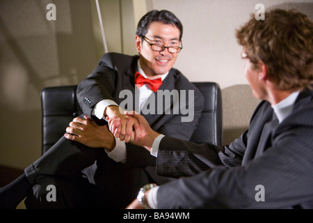 Multi-racial businessmen shaking hands on a deal Stock Photo