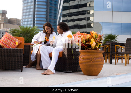 African-American couple sitting on rooftop terrace by in city Stock Photo