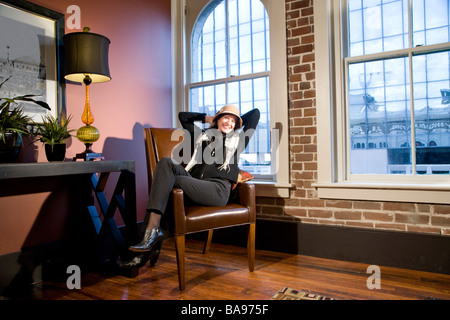 Middle-aged woman sitting in modern downtown loft Stock Photo