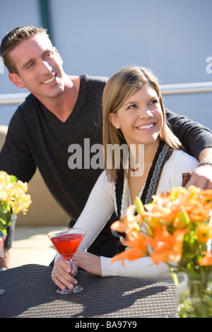 Young couple with martinis on rooftop of downtown condo Stock Photo