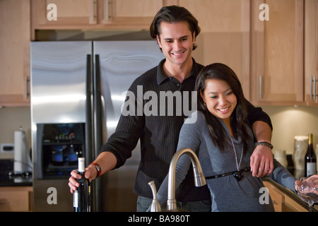 Young multi-racial couple standing in kitchen Stock Photo