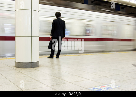 Japanese businessman waits for his train in Tokyo