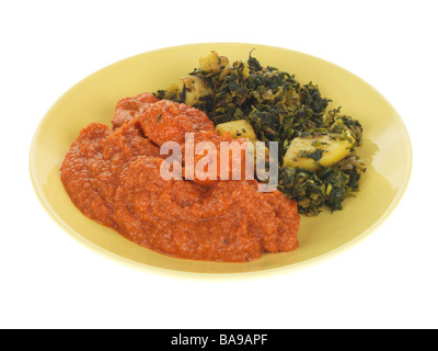 Freshly Cooked Indian Style Chicken Tikka Masala Curry With Sag Aloo Spinach And Potatoes Isolated Against A White Background With No People Stock Photo