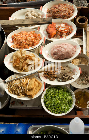 Bowls of fresh ingredients lined up on a boat at the floating market near Bangkok ready for cooking Thailand Stock Photo