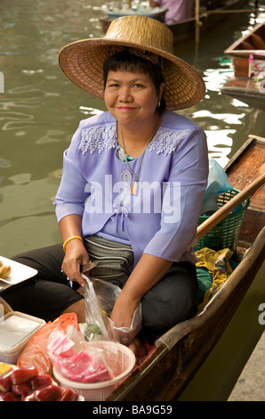 A Thai woman market trader smiles for the camera from her boat at Damnoen Saduak Floating Market near Bangkok Thailand Stock Photo