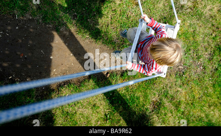 Baby blonde boy on the swing / seesaw alone Stock Photo