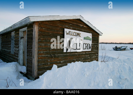 'Welcome to Old Crow' sign on log shed in Old Crow, Yukon Territory, Canada in the winter. Stock Photo