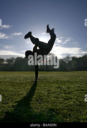 The silhouette of a man doing a handstand on one hand Stock Photo