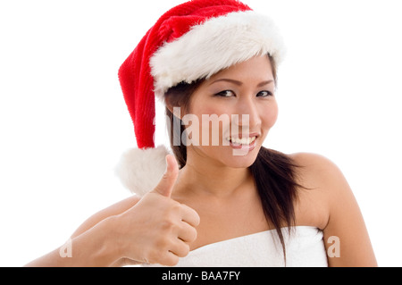 young woman with christmas hat showing thumb up Stock Photo