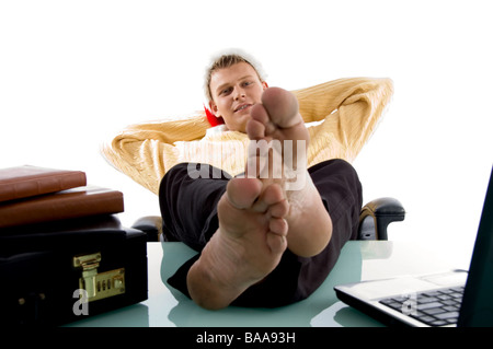 man wearing chritsmas hat in relaxing mode with legs on desk Stock Photo
