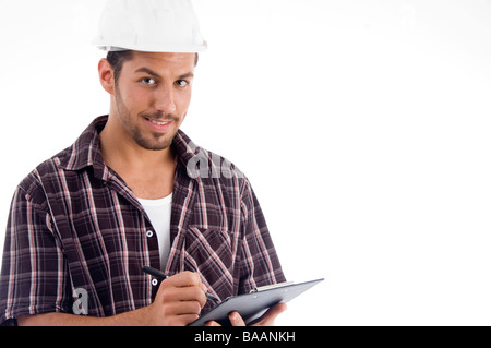 engineer writing on pad and looking at camera Stock Photo