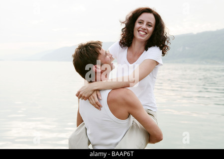 couple laughing hugging at the lakeside Stock Photo