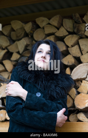 Woman in front of firewood - Frau vor einem Stapel Brennholz Stock Photo