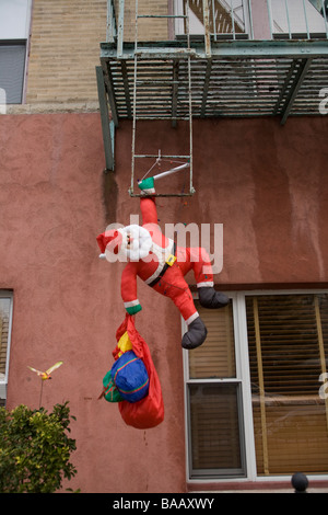 Santa Claus coming down a fire escape rather than a chimney in Brooklyn New York Stock Photo