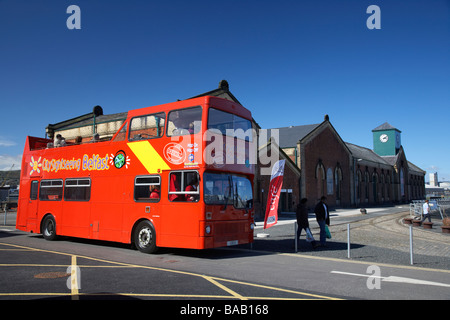 red sightseeing belfast tourist open decked bus tour at the former thompsons pump house at the dry graving dock Stock Photo