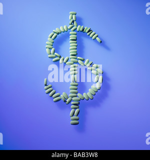 green pills laid out in the dollar money sign symbol on blue background Stock Photo