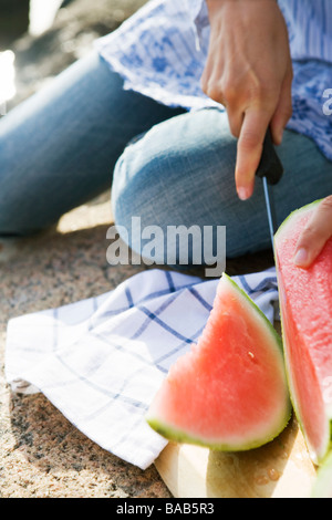 A woman cutting up a watermelon, Sweden. Stock Photo