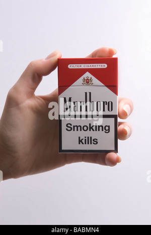 Woman's hand holding a pack of Marlboro red against a white background Stock Photo