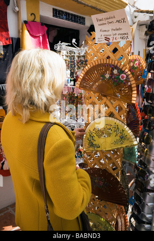 Marbella Malaga Province Costa del Sol Spain Woman looking at hand painted fans on sale in old town Stock Photo