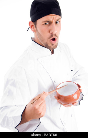 young chef holding bowl and chopstick and looking at camera Stock Photo