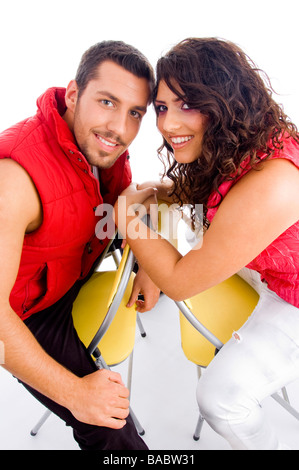 young couple sitting on chair and looking at camera Stock Photo