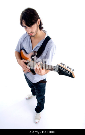 handsome male looking at camera and playing guitar on an isolated white background Stock Photo